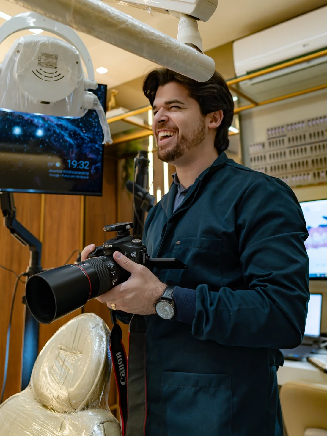 Dr. Danilo Vital sorrindo, com sua câmera no consultório